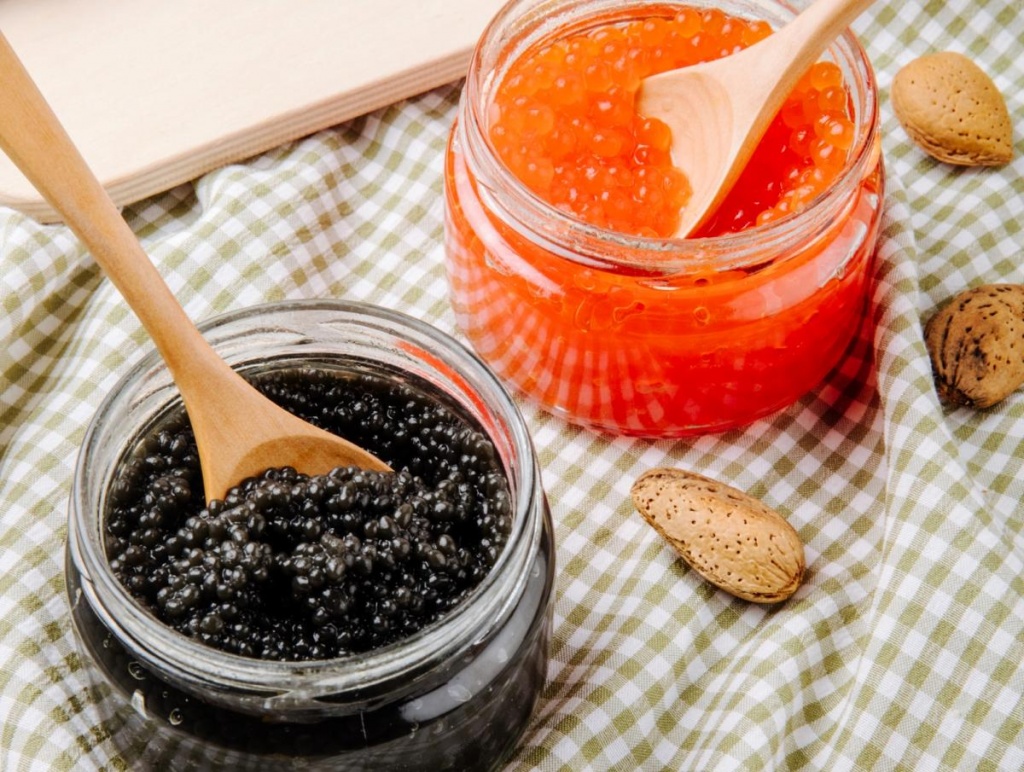 side-view-black-red-caviar-jar-with-wooden-spoon-almond-table.jpg